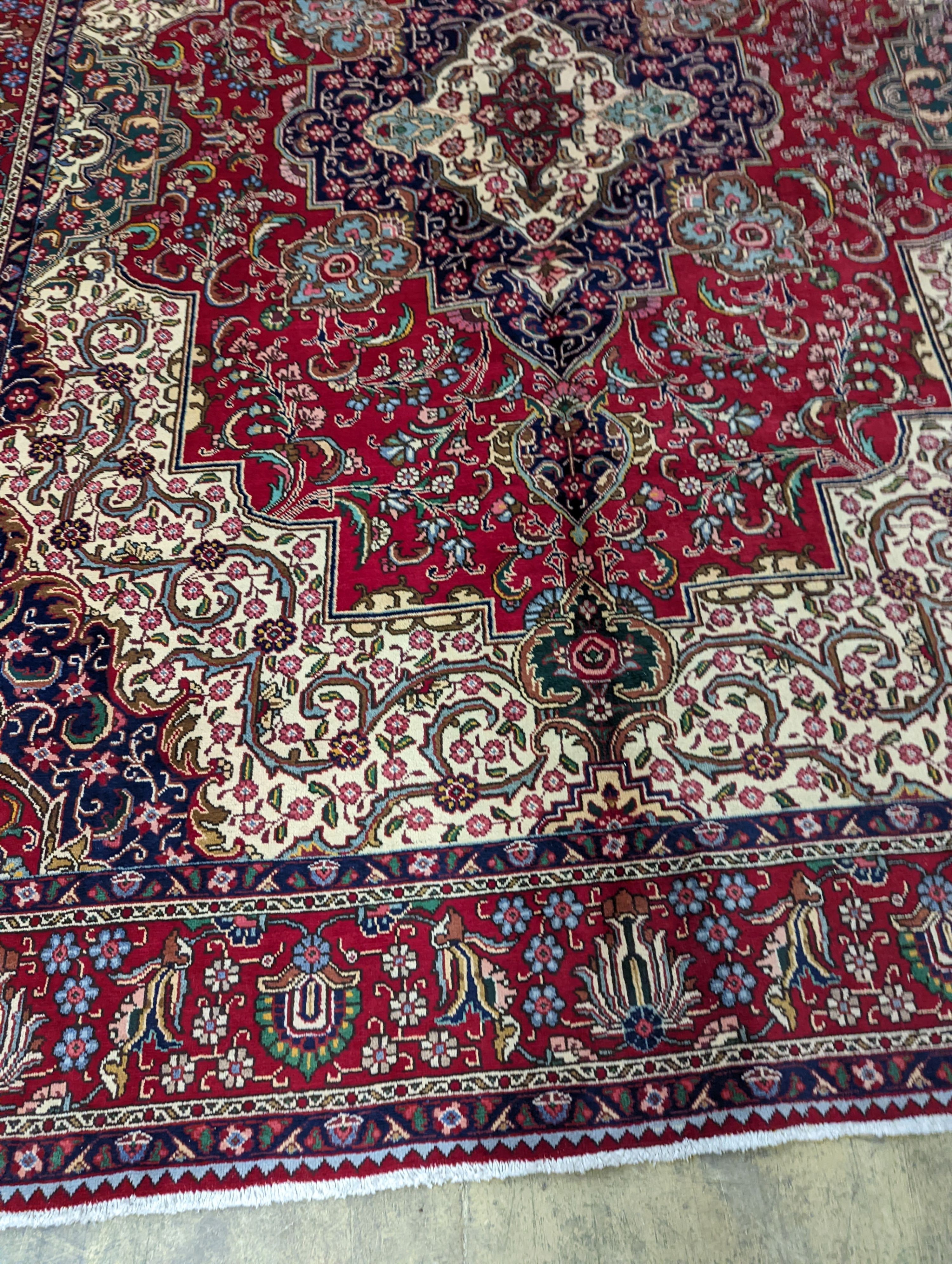 A Tabriz red ground carpet, 405 x 292cm